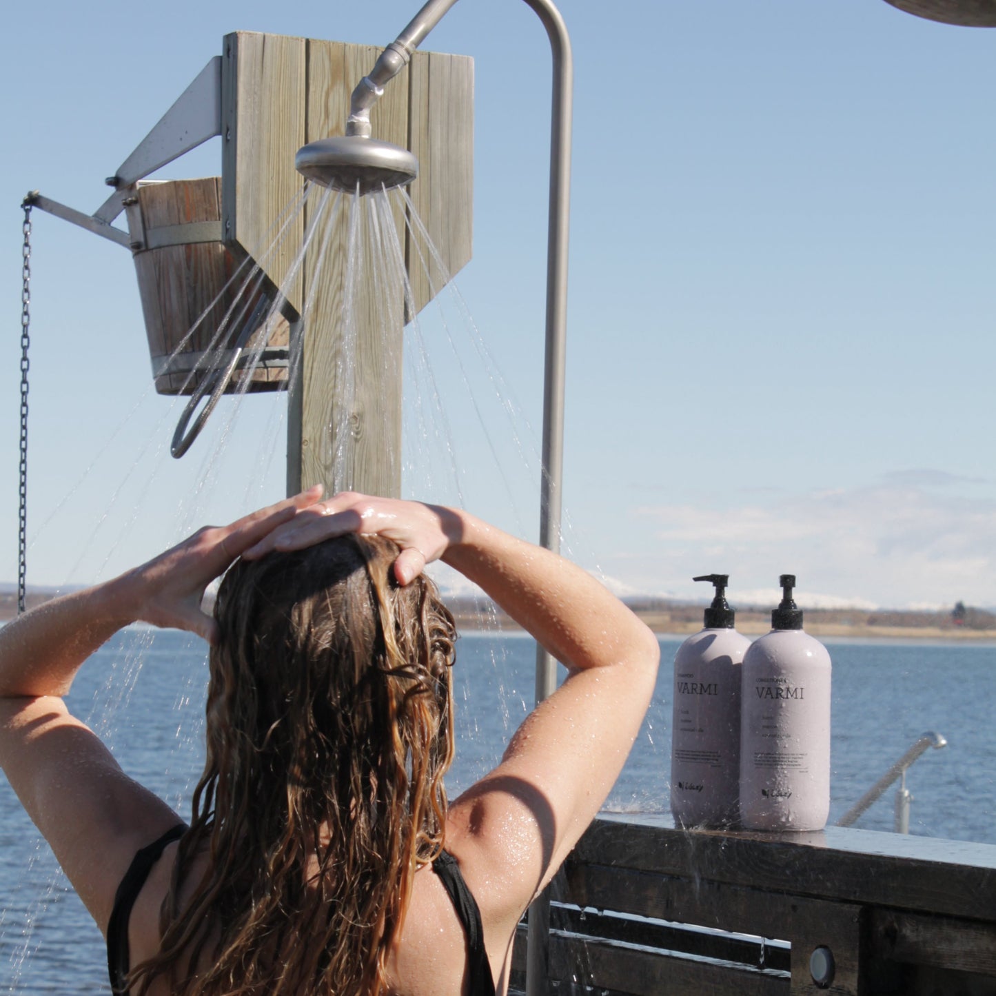 Model using Varmi Shampoo and Conditioner in an outdoor SPA